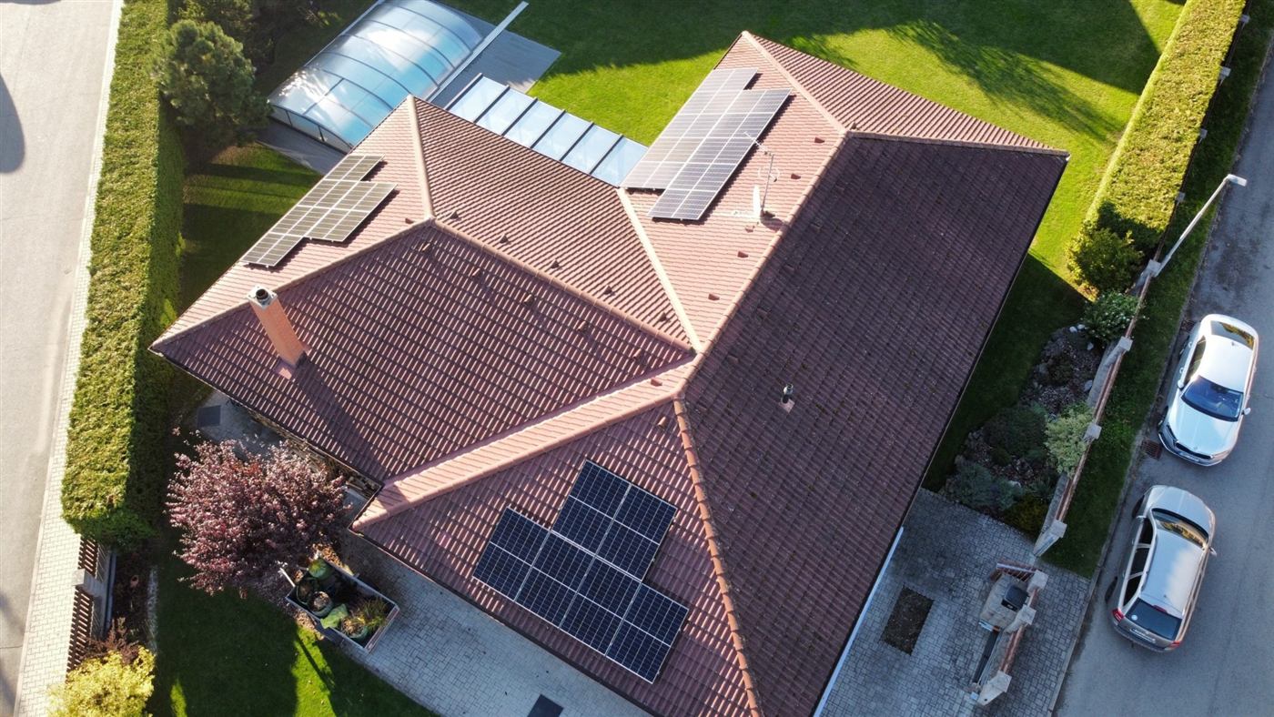 Letecký pohled na rodinný dům s panely na třech stranách střechy