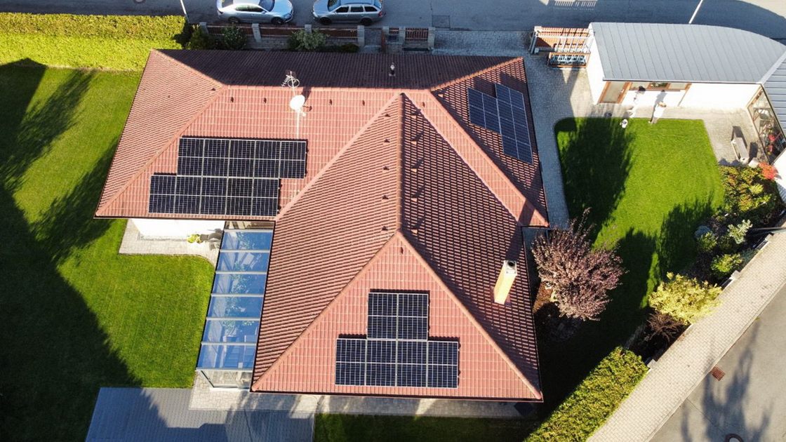 Rodinný dům s fotovoltaickými panely na střeše, pohled z dronu