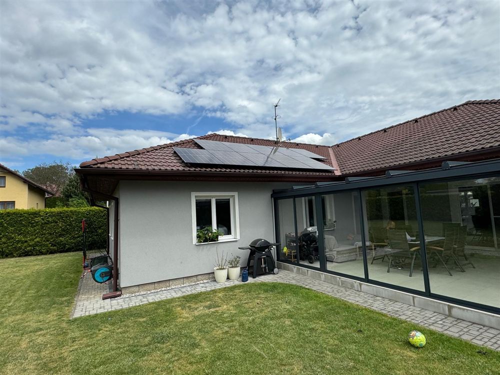 Bungalov s panely na střeše a prosklenou terasou