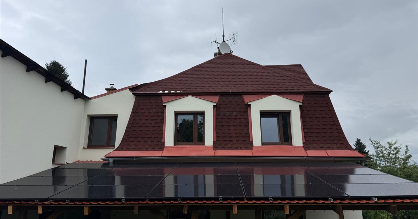 Černé panely na střeše terasy pod mansardovou střechou, zataženo