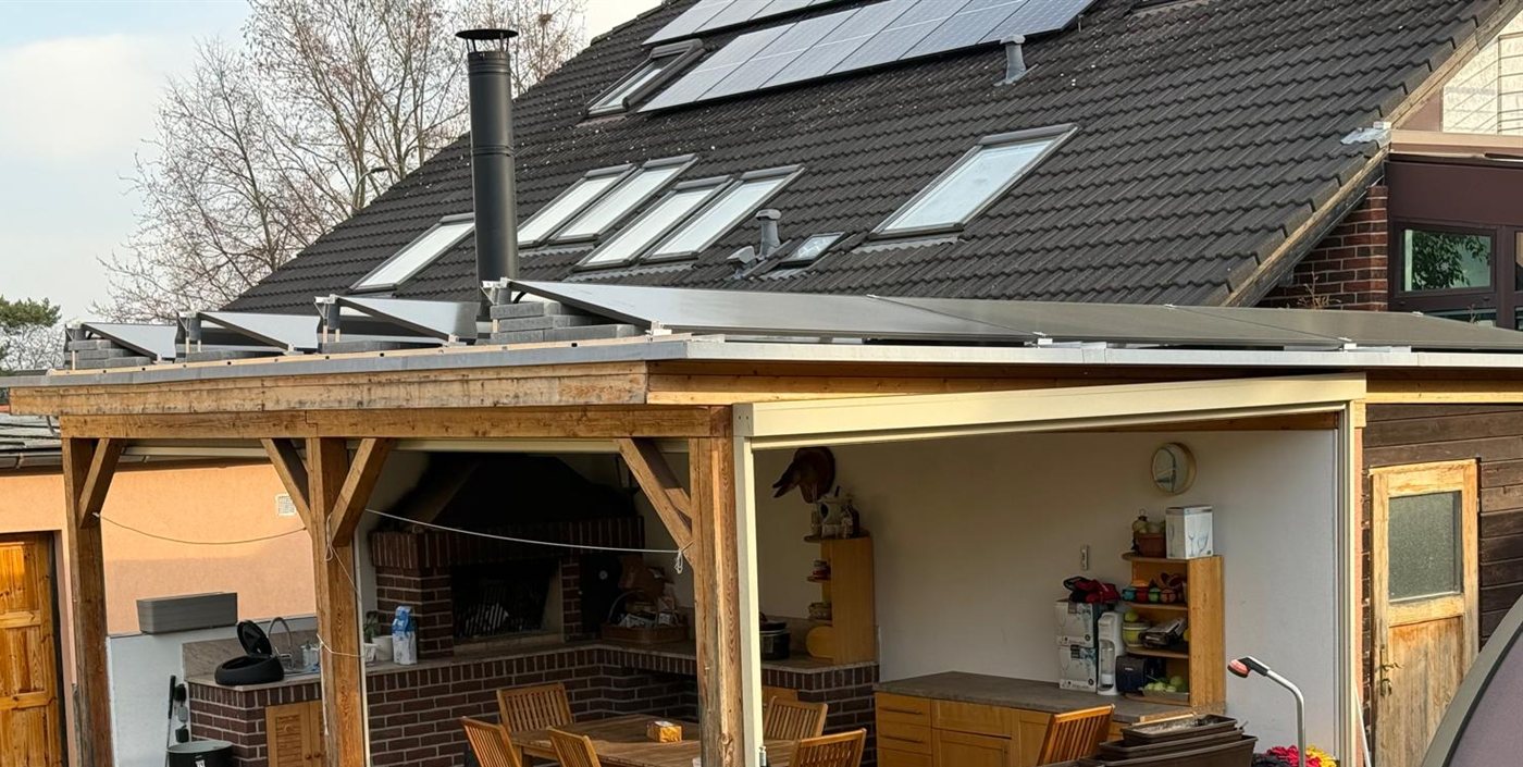 Panely na ploché střeše pergoly a na sedlové střeše domu s okny