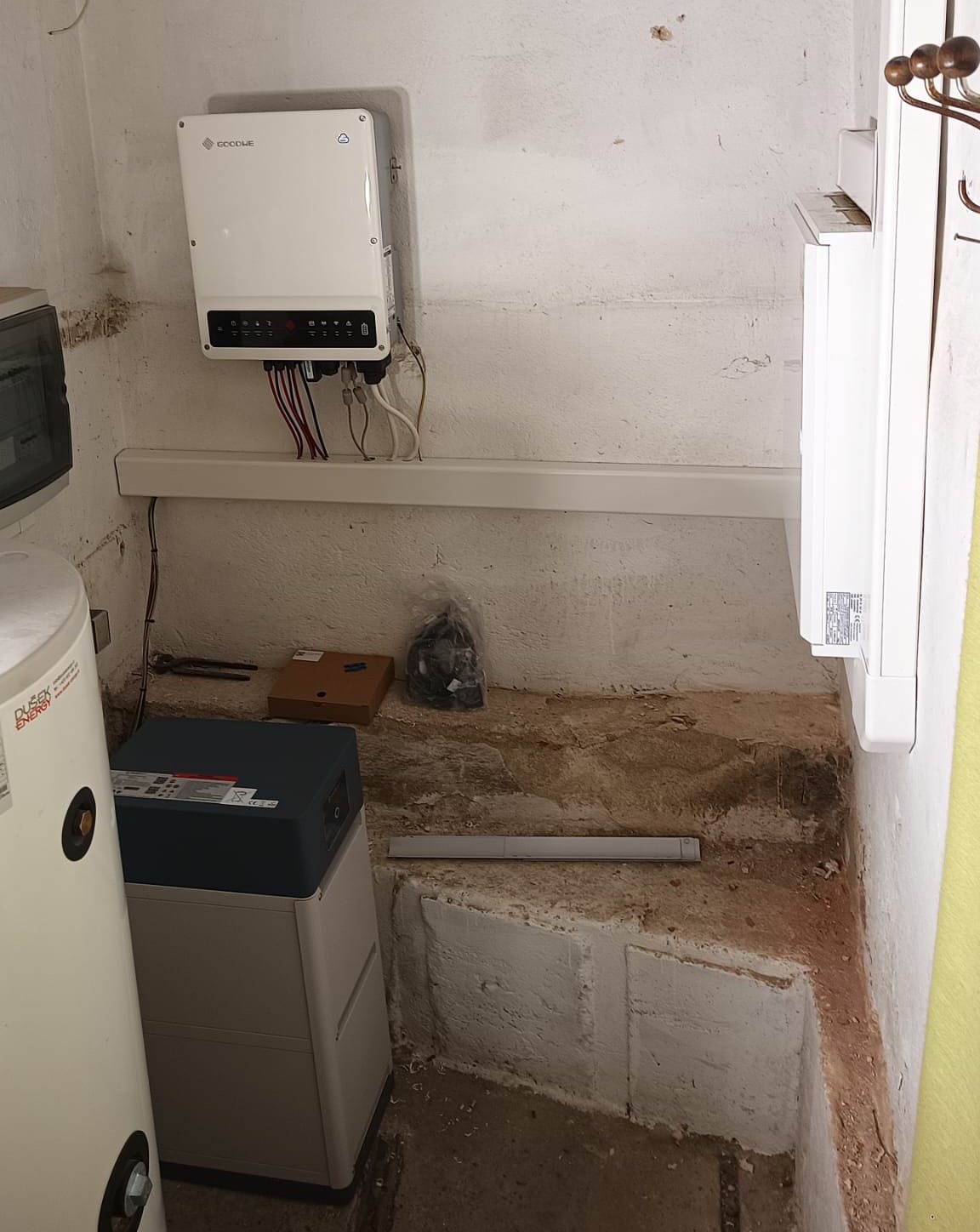 Střídač, rozvaděč a baterie v technické místnosti vedle zásobníku vody