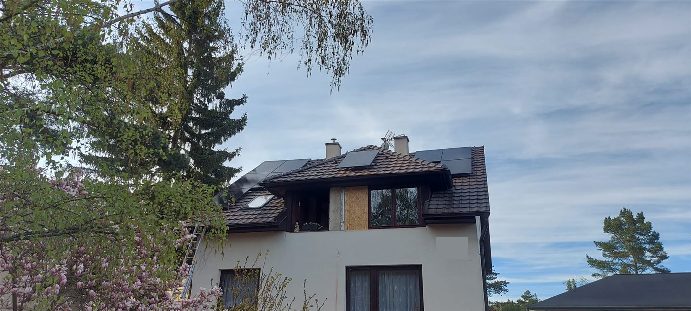 Dům s panely na střeše mezi stromy