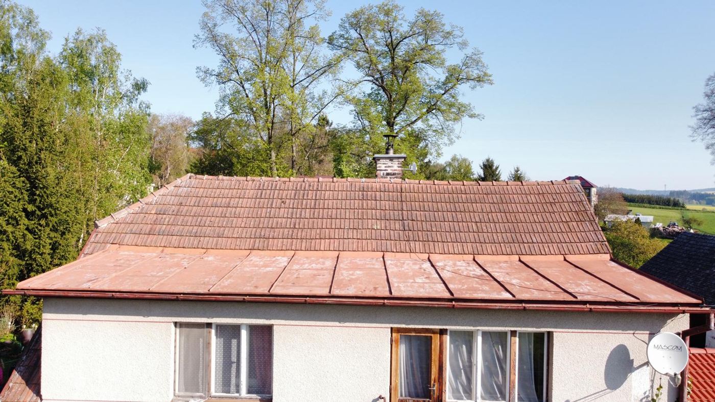Rodinný dům před rekonstrukcí: stará střecha z tašek a plechu
